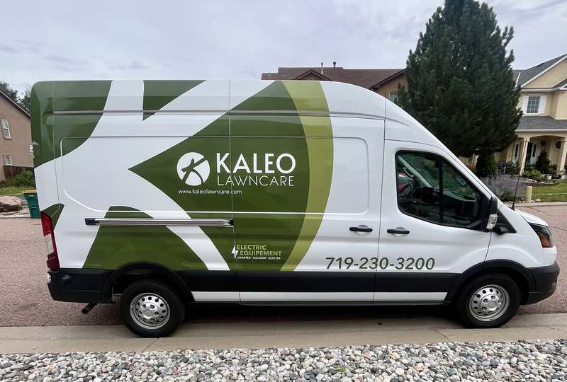 The Kaleo Lawncare van, wrapped in green and white and marked electric equipment, parked on a residential street